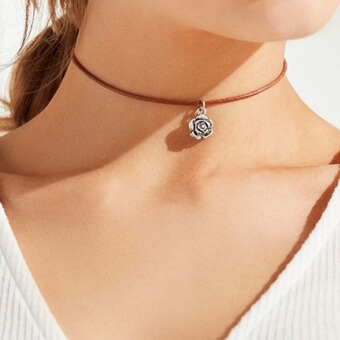model wearing choker necklace with rose pendant